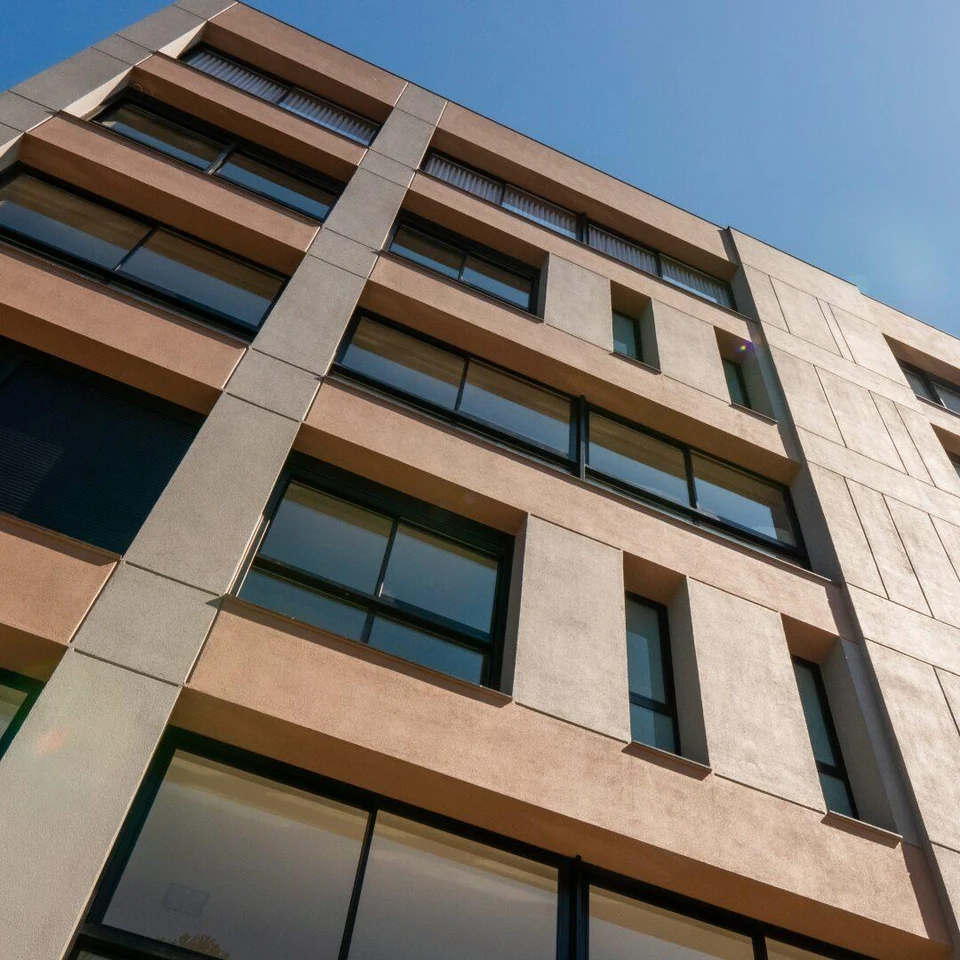 Modern multi-storey facade with geometric exterior panels and dark window frames