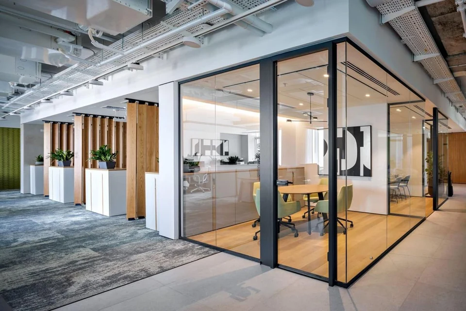Black-framed glass partitions enclosing meeting rooms in a modern office